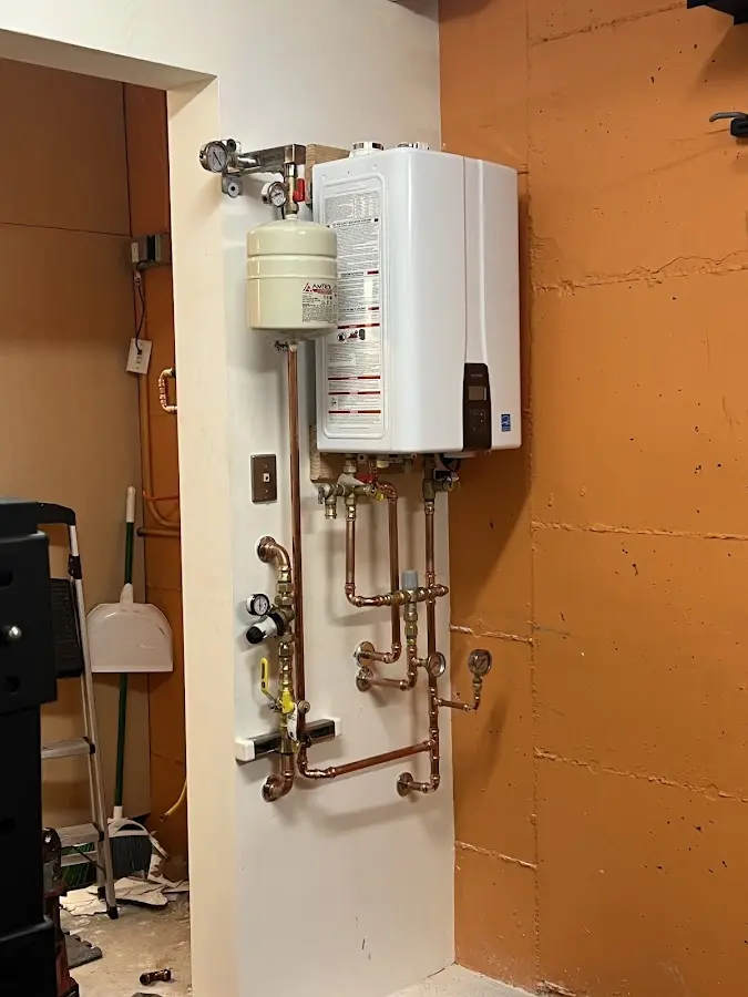 Plumbing technician inspecting water heater connections in Rushville